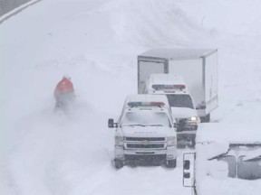 SQ officers on snowmobile, and safety crews try to clear up Highway 13 near Cote de Liesse road on Wednesday March 15, 2017 following massive snow storm that left many motorists stranded overnight.