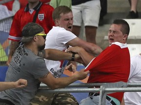 In this June 11, 2016 file photo, Russian supporters attack an England fan at the end of a Euro 2016 group-stage between England and Russia in Marseille, France.
