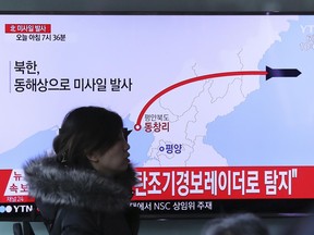 A visitor walks by the TV screen showing a news program reporting about North Korea's missile firing, at Seoul Train Station in Seoul, South Korea, March 6, 2017.