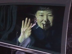 Ousted South Korean President Park Geun-hye waves to her supporters from her vehicle upon her arrival at her private home in Seoul