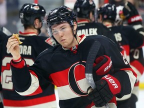 In this March 19, 2015 file photo, Senators forward Curtis Lazar eats a burger that was thrown on the ice in Ottawa. Lazar was dealt to the Calgary Flames on March 1.