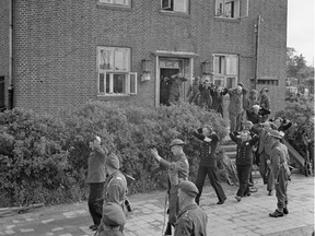 Officials are escorted out of a north German sports school that served as the last headquarters of the Third Reich.