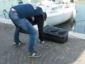 Police examine a suitcase found at a marina on Italy's Adriatic coast.