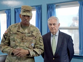 Secretary of State Rex Tillerson is briefed by Gen. Vincent K. Brooks as a North Korean soldier takes a photograph through a window at a meeting room in Panmunjom, which has separated the two Koreas since the Korean War, on March 17, 2017.