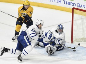 Toronto Maple Leafs' goaltender Frederik Andersen tries to snare a loose puck with the help of defenceman Morgan Reilly during NHL action Thursday night in Nashville. Lurking about is Kevin Fiala. Andersen had another strong performance  with 29 saves as the Leafs posted a 3-1 victory to solidify their hold on a playoff spot in the Eastern Conference.