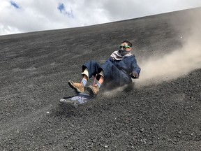 The author's husband slides down the face of Nicaragua's Cerro Negro volcano on a sand board.