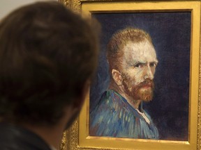 A man looks at a self portrait by Vincent Van Gogh
