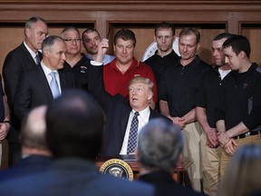 President Donald Trump, accompanied by Interior Secretary Ryan Zinke, left, and Environmental Protection Agency (EPA) Administrator Scott Pruitt, second from left, and others, holds up a pen he used to sign an Energy Independence Executive Order, Tuesday, March 28, 2017, at EPA headquarters in Washington.