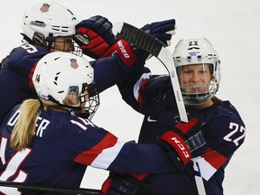In this Feb. 17, 2014 file photo, Kacey Bellamy of the United States, right, is congratulated by teammates after scoring a goal against Sweden at the Sochi Olympics.