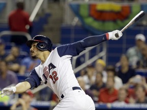 Nolan Arenado, of the United States, follows through on his three-run home run against Canada in the second inning in a first-round game of the World Baseball Classic, Sunday in Miami.