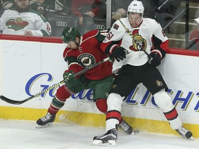 Jared Spurgeon, left, of the Minnesota Wild and Mark Stone of the Ottawa Senators have a board meeting during Thursday's NHL game in Minnesota. The Wild handed the Sens their third straight defeat, this one by a 5-1 count.