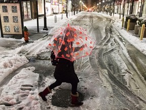 A woman crosses a street during a winter storm in Philadelphia, Tuesday, March 14, 2017