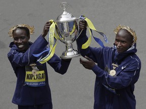 Edna Kiplagat, left and Geoffrey Kirui, both of Kenya, hold a trophy together after their victories in the 121st Boston Marathon on Monday, April 17, 2017, in Boston.