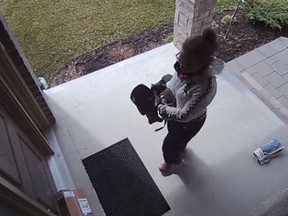 A surveillance camera video showing a woman taking a parcel from a doorstep in London, Ontario