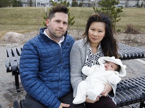 Michael Janz and Sally Tang pose with their baby boy, Miles, at Hodgson Park in Edmonton, Alta., on Thursday, April 13, 2017. The family has been given eight months to find a new place to live because their condo building doesn't allow children. (Codie McLachlan/National Post)