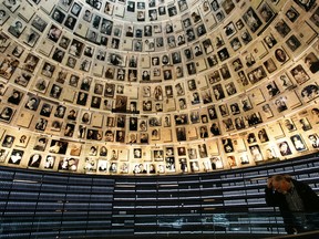 A visitor pauses under photographs of Jewish victims of the Nazis in the Hall of Names at the Yad Vashem Holocaust Memorial  in 2005.