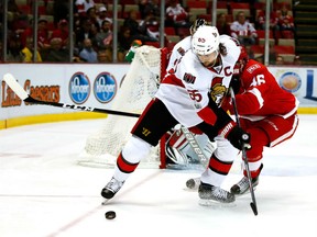 Erik Karlsson of the Ottawa Senators battles for the puck with Ben Street of the Detroit Red Wings during the first period at Joe Louis Arena on Monday in Detroit.