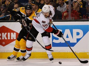 Ottawa Senators defenceman Erik Karlsson (right) eludes Boston Bruins forward Dominic Moore on April 17.