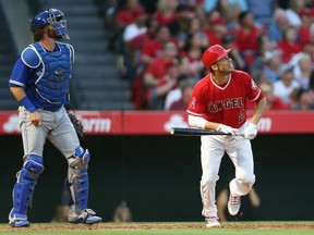 Andrelton Simmons of the Angels and catcher Jarrod Saltalamacchia of the Toronto Blue Jays watch Andrelton's grand slam home run in the third inning at Angel Stadium of Anaheim on Saturday night in Anaheim, Calif.