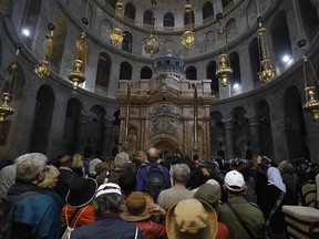 Tourists and worshippers wait to access the newly restored shrine surrounding what is believed to be Jesus's tomb which was unveiled at a ceremony in Jerusalem on March 22, 2017 following months of delicate work.