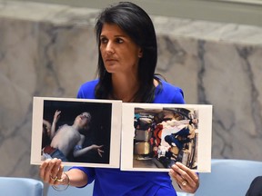 US Ambassador to the UN, Nikki Haley holds photos of Syrian victims as she speaks as the UN Security Council meets in an emergency session at the UN on April 5, 2017.