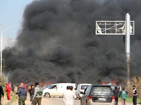 A picture taken on April 15, 2017, shows smoke billowing following a suicide car bombing in Rashidin, west of Aleppo, that targeted buses carrying Syrians evacuated from two besieged government-held towns of Fuaa and Kafraya. At least 40 people were killed in a suicide car bombing near buses carrying Syrians evacuated from two besieged government-held towns, the Syrian Observatory for Human Rights said.