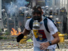 A demonstrator runs during a protest against Venezuelan President Nicolas Maduro, in Caracas on April 19, 2017