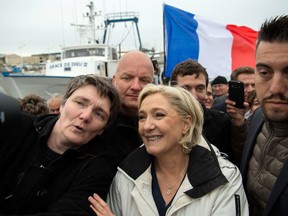 Marine Le Pen poses for a selfie with a fan as she leaves after meeting fishermen in the harbour of Le Grau-du-Roi, southern France, on early April 27, 2017