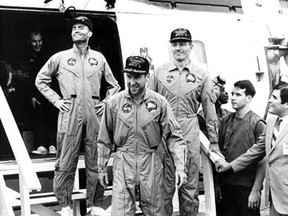 Apollo 13 astronauts (left to right) Fred W. Haise, James A. Lovell and John L. Swigert, leave a helicopter to step aboard Iwo Jima in the Pacific after splashdown on April 17, 1970.