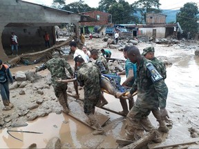 In this handout photo released by the Colombian National Army, soldiers carry a victim on a stretcher, in Mocoa, Colombia, Saturday, April 1, 2017, after an avalanche of water from an overflowing river swept through the city as people slept. The incident triggered by intense rains left at least 100 people dead in Mocoa, located near Colombia's border with Ecuador.