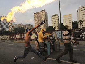 An anti-government protesters throws a molotov bomb at security forces in Caracas, Venezuela, Wednesday, April 19, 2017