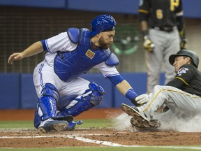 Pittsburgh Pirates' Adam Frazier is tagged out at home by Toronto Blue Jays catcher Russell Martin during the fifth inning of their pre-season game in Montreal on Friday night.
