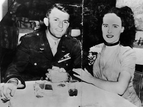 American aspiring actress and murder victim Elizabeth Short (1924 - 1947), known as the 'Black Dahlia,' sits arm-in-arm at a restaurant or bar table with American Amy Major Matthew M. Gordon Jr (? - 1945), mid 1940s. It is not proven as to whether the couple were engaged although Short claimed that they were.