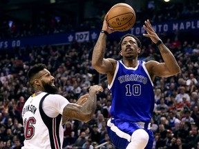 Miami Heat forward James Johnson looks on as the Raptors' DeMar DeRozan drives to the hoop during second half of their game in Toronto on Friday night.