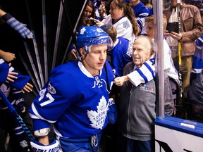 Vic Braknis (in grey shirt), a 25-year-veteran of the Toronto Maple Leafs' usher corps, watches as forward Leo Komarov skates onto the ice at Air Canada Centre.