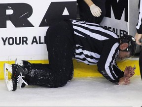 In this Jan. 27, 2016 file photo, NHL linesman Don Henderson goes down after a collision with Calgary Flames defenceman Dennis Wideman.
