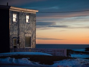 The rising sun illuminates the shingles of a cliffside home in the onetime coal-mining town of Glace Bay, Nova Scotia.