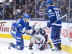 James van Riemsdyk, left, of the Toronto Maple Leafs, gets tangled up with Columbus Blue Jackets' Scott Harrington during NHL action Sunday in Toronto. At right is Leafs' Mitch Marner. The Blue Jackets were 3-2 winners. relegating Toronto to the eighth and final seed in the NHL playoffs.