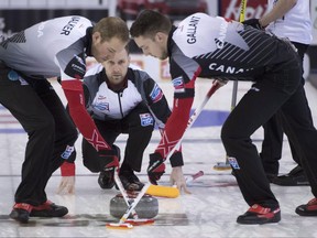 Canada skip Brad Gushue makes a shot as lead Geoff Walker and second Brett Gallant sweep against Italy on April 6.