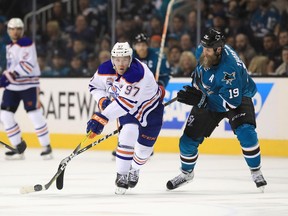 Edmonton Oilers forward Connor McDavid (left) controls the puck in front of San Jose Sharks forward Joe Thornton on April 22.