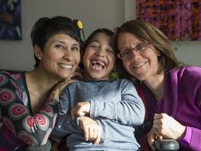 Natasha Bakht (left) and Lynda Collins (right) pose for a family photo with their seven year old son Elaan Bakht in Ottawa, Ontario