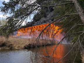 Flames engulf a wooden trestle bridge on the outskirts of Mayerthorpe, Alta. on Tuesday, April 26. 2016.