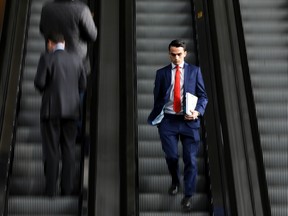 Businessmen use a set of escalators at the Leadenhall Building in London, U.K.