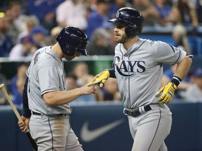 Evan Longoria, right, of the Tampa Bay Rays, is congratulated by teammate Brad Miller after hitting an eighth-inning homerun against the Toronto Blue Jays during MLB action Friday at the Rogers Centre. The Rays posted a 7-4 victory.