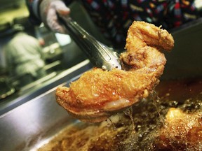 In this 2006 file photo, H. Kenneth Woods, chef and owner of Sylvia's restaurant, cooks southern fried chicken using a soy bean oil that doesn't contain trans fats in New York's Harlem neighborhood. A study released Wednesday, April 12, 2017 suggests restrictions on heart-damaging fats in restaurant food may have helped prevent heart attacks in several New York counties.