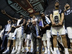 North Carolina head coach Roy Williams, centre, celebrates with his team after the championship game against Gonzaga at the Final Four NCAA college basketball tournament, Monday in Glendale, Ariz.