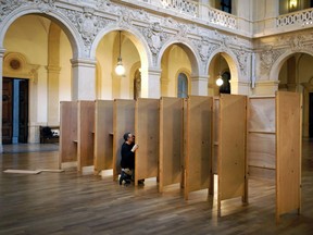 A worker prepares the booths at a polling station in Lyon, central France, Saturday, April 22, 2017. The two-round presidential election will take place on April 23 and May 7.