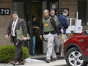 FBI agents leave the office of Dr. Fakhruddin Attar at the Burhani Clinic in Livonia, Mich. Friday, April 21, 2017, after completing a search for documents. The investigation is connected to the case of Dr. Jumana Nagarwala, of Northville, charged with performing genital mutilation on two young girls from Minnesota.