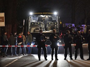 In this April 11 file photo, German police officers stand in front of Dortmund's damaged team bus after explosions that injured two people before a Champions League quarterfinal match.