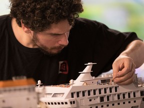 Ricardo Martinez, of Argentina, puts final touches on a cruise ship in the Latin America section of the Gulliver's Gate exhibit in New York.
